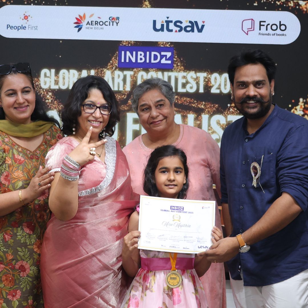 Young artist proudly holding her certificate with proud teachers and family